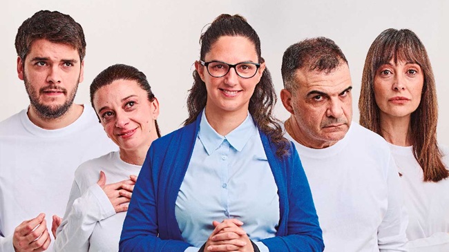 Cinco actores de la obra Baile de Huesos posando para el cartel promocional; la actriz central lleva gafas y camisa azul, rodeada por sus compañeros en el Teatro Real Carlos III.
