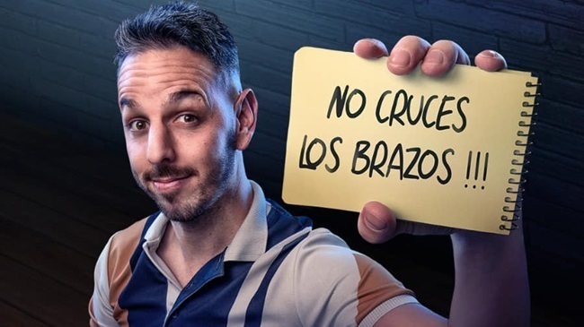 David Cepo sujetando un cuaderno que dice "No cruces los brazos !!!" para su monólogo en el CAEM de Salamanca.