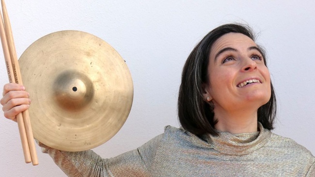 Retrato de la percusionista Lucía Martínez sosteniendo baquetas y un platillo en promoción de su concierto en el Teatro Juan del Enzina de Salamanca.